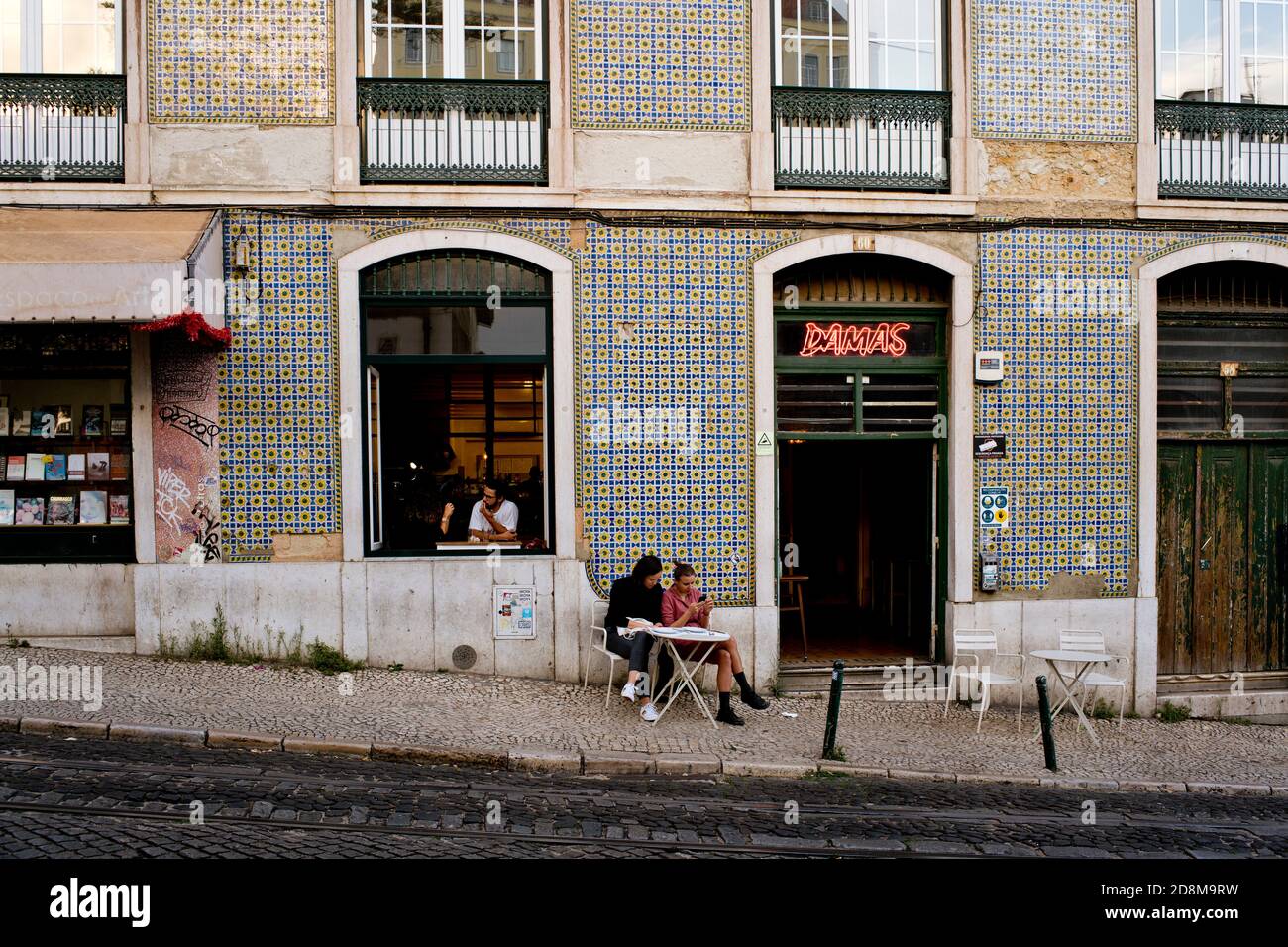 Menschen hängen in und vor einem Café in einem Gebäude in Azulejos in Lissabon, Portugal Stockfoto