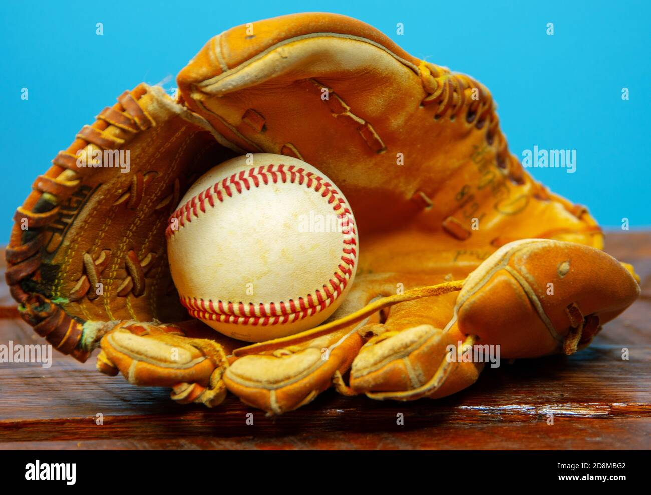 Ein Wetter-Baseballhandschuh aus Leder mit einem Baseball im Handschuh. Stockfoto