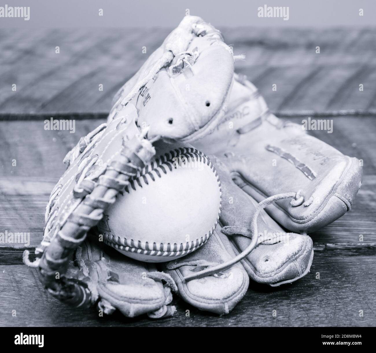 Ein Wetter-Baseballhandschuh aus Leder mit einem Baseball im Handschuh. Stockfoto