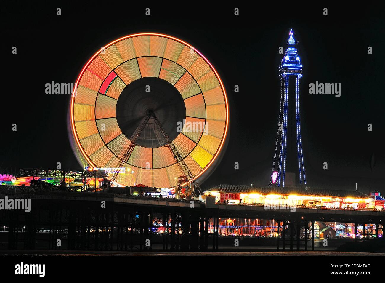 Die vielen Farben des Blackpool Tower und das Riesenrad Nachts während der jährlichen Beleuchtung Stockfoto