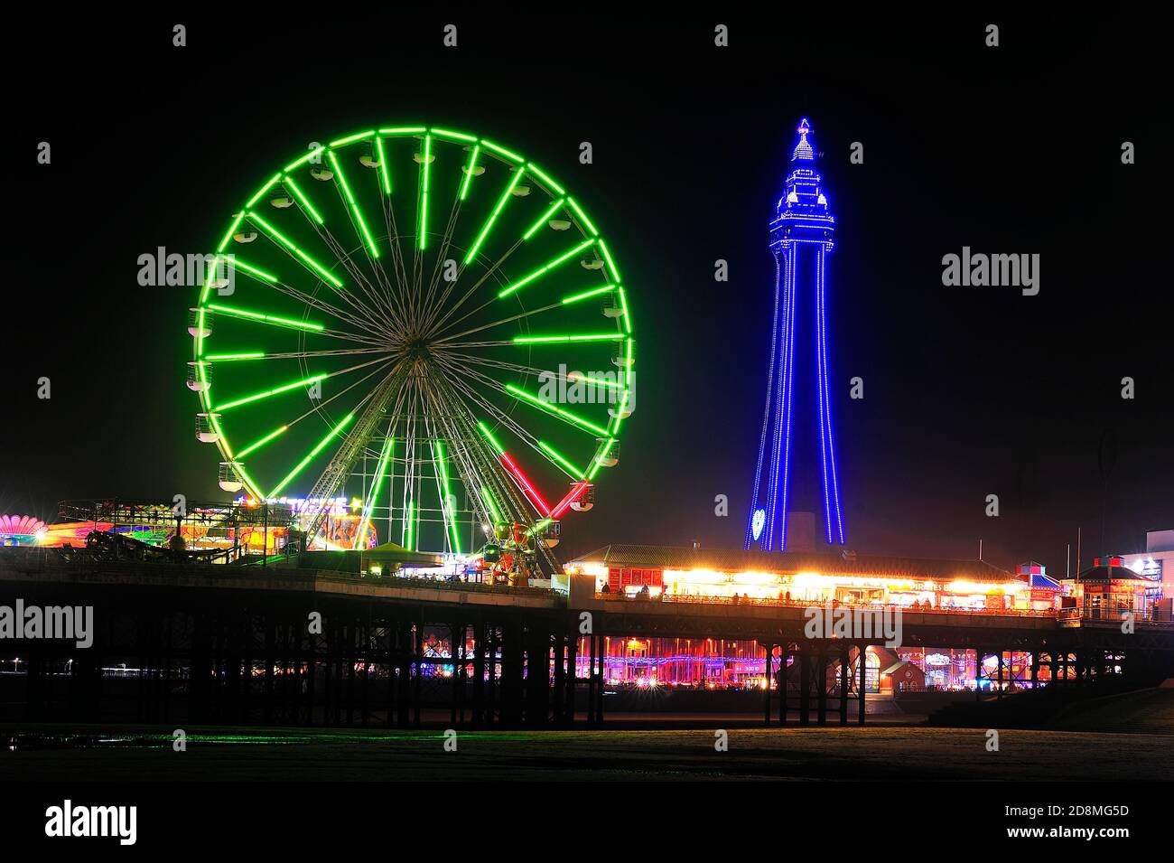 Die vielen Farben des Blackpool Tower und das Riesenrad Nachts während der jährlichen Beleuchtung Stockfoto
