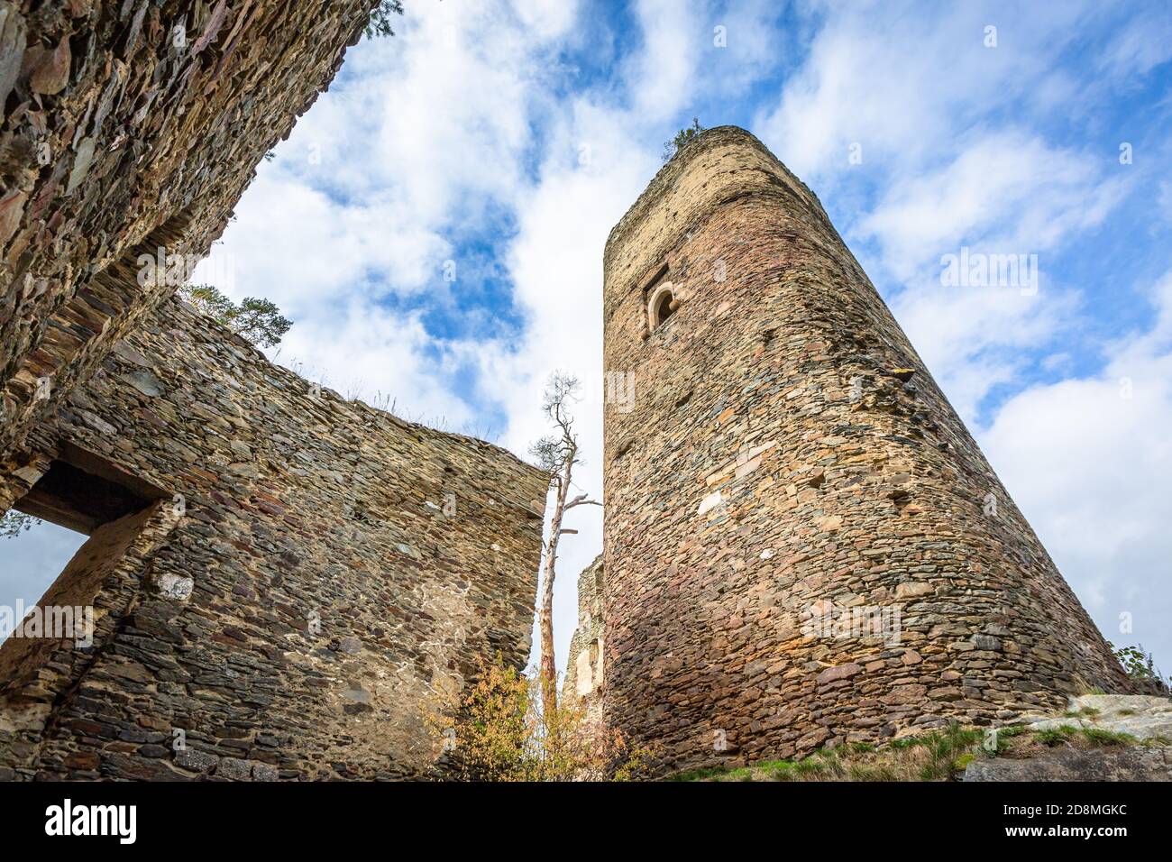 Gutstejn / Tschechische Republik - Oktober 10 2020: Blick von unten auf einen hohen Steinturm und eine Mauer, ein Teil der Ruine der mittelalterlichen gotischen Burg. Stockfoto