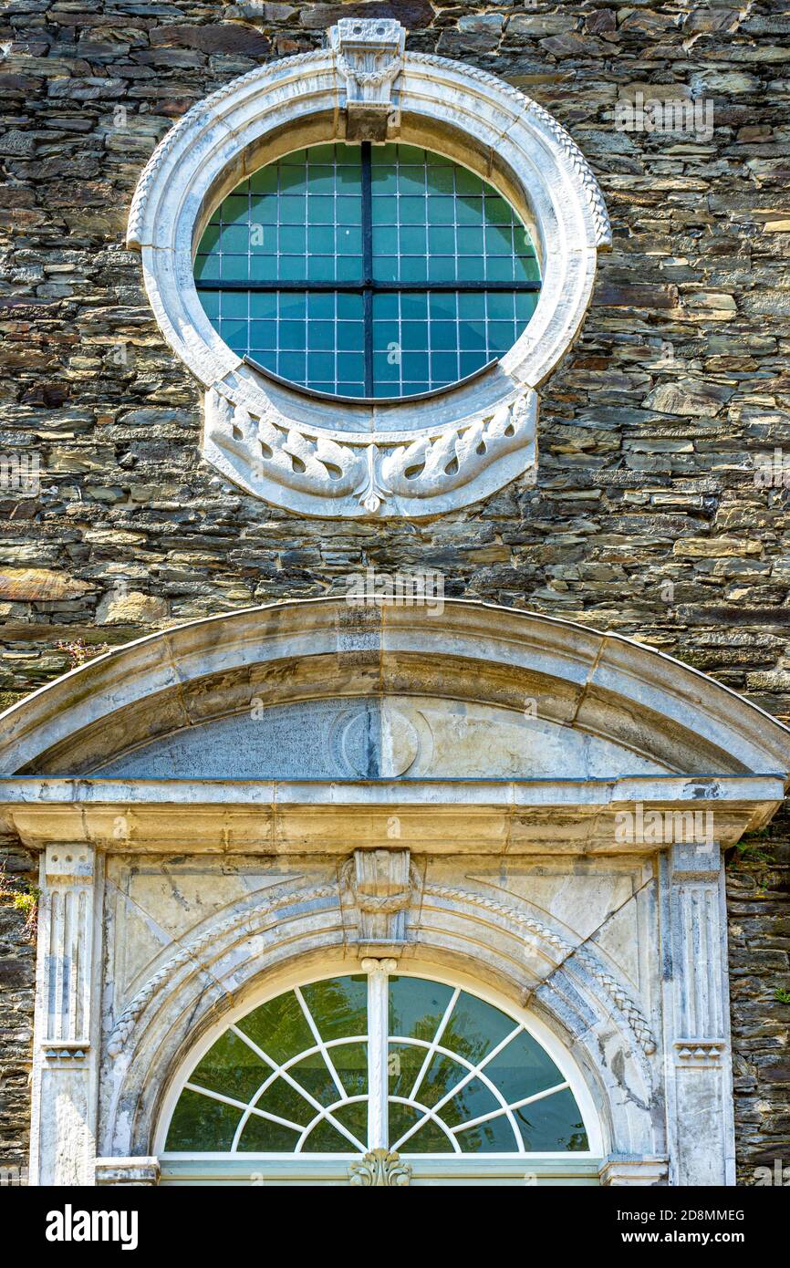 Vertikale Aufnahme eines runden Fensters an einer Steinmauer Gebäude Stockfoto