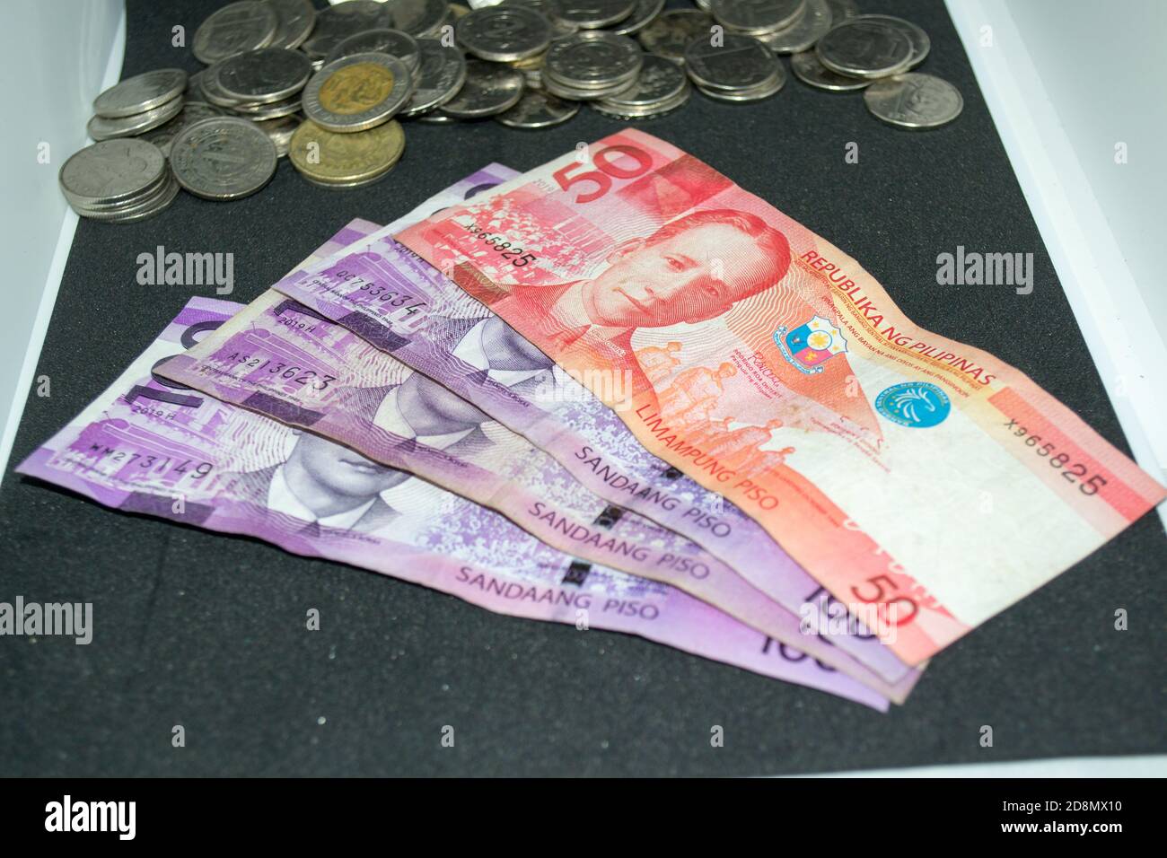 100 und 50 philippinische Peso-Scheine und philippinische Peso-Münzen Stockfoto