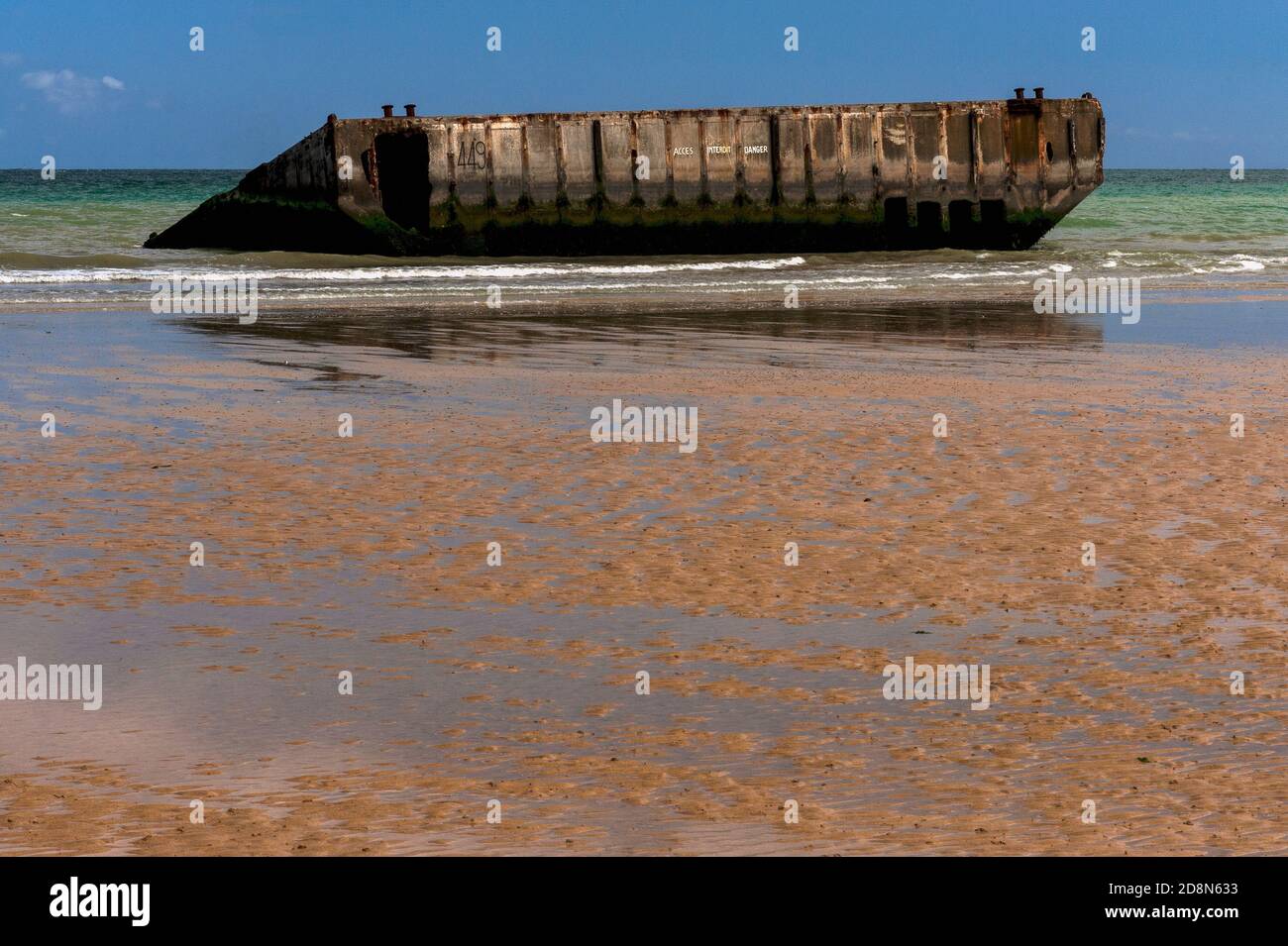 Bei Ebbe in Arromanches, Calvados, Normandie, Frankreich, Die Menschen können zu Fuß an den Rand des Wassers auf dem Zweiten Weltkrieg ‘Gold Beach’ zu erreichen - aber nicht betreten - vorgegossene Betonabschnitte von Port Winston oder Mulberry Harbour B. Dies war der 600,000-Tonnen-vorgefertigte tragbare Hafen, der über den Ärmelkanal geschleppt wurde, Vor der Küste montiert und dann für 10 Monate nach der Operation Overlord ‘D-Day’ Invasion vom 6. Juni 1944 verwendet, um 2.5 Millionen britische und kanadische Truppen, eine halbe Million Fahrzeuge und vier Millionen Tonnen Vorräte zu landen. Stockfoto