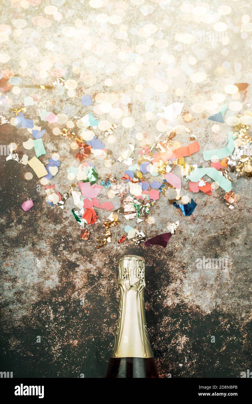 Frohes neues Jahr. Silvester Feier Konzept Hintergrund.Champagner-Flasche mit Konfetti über Grunge Hintergrund Stockfoto