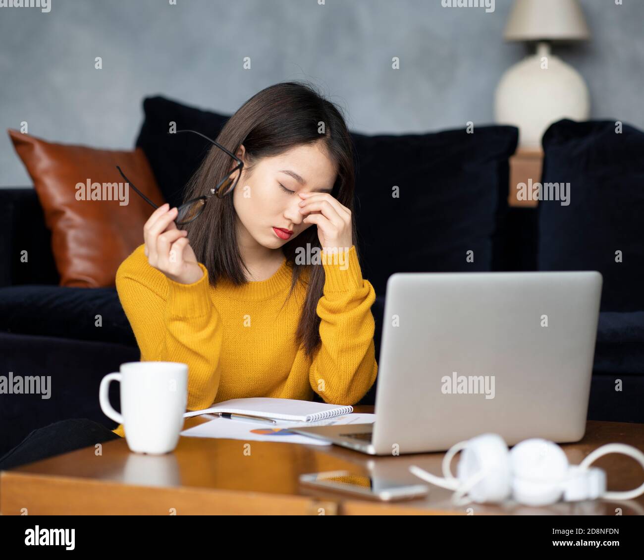 Asiatische Frau zu Hause arbeiten, schreiben Notebook. Schöne japanische Freiberuflerin Stockfoto