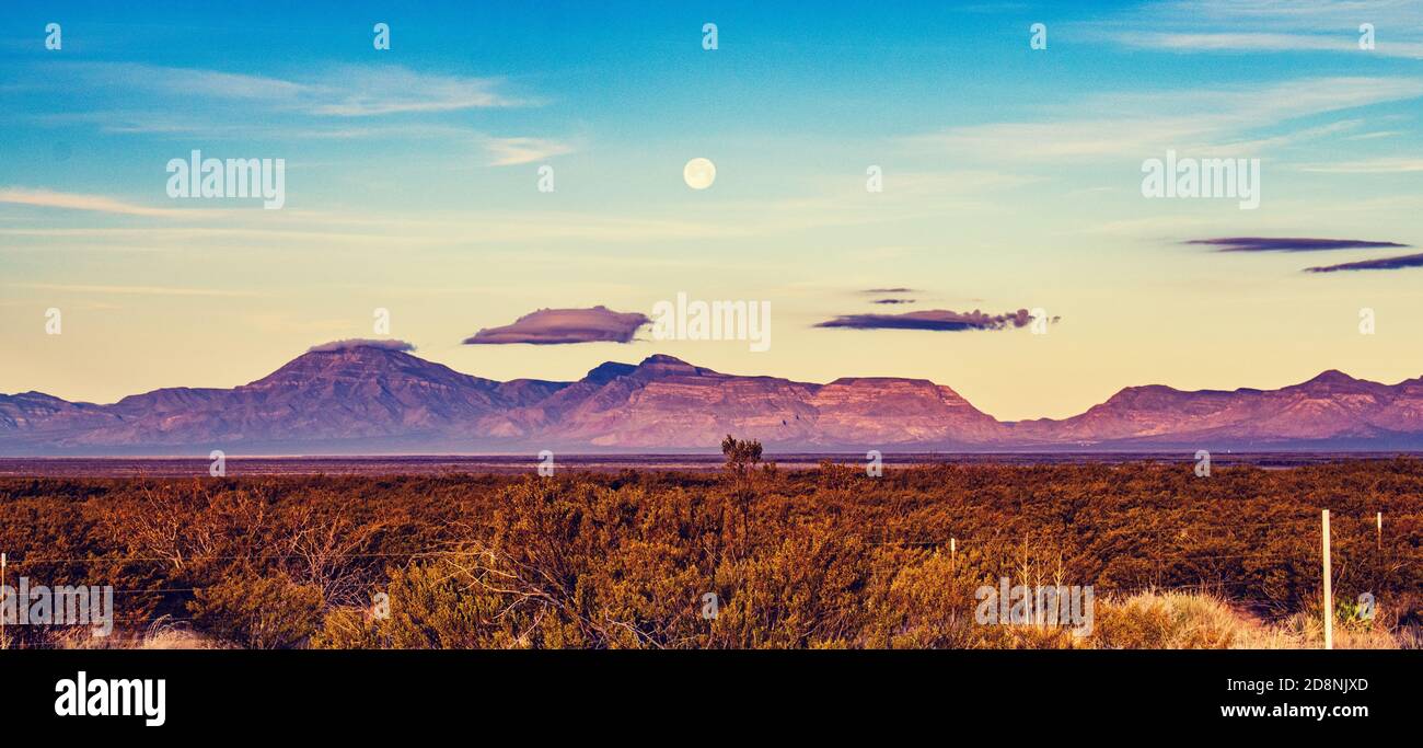 Frühmorgendliche Landschaft in New Mexico, mit Bergen und einem untersetzlichen Mond. Stockfoto