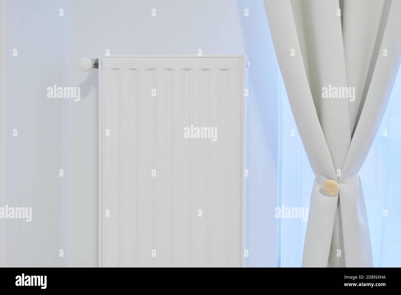 Weißer Heizkörper mit Temperaturthermostat im Inneren der Wohnung Stockfoto