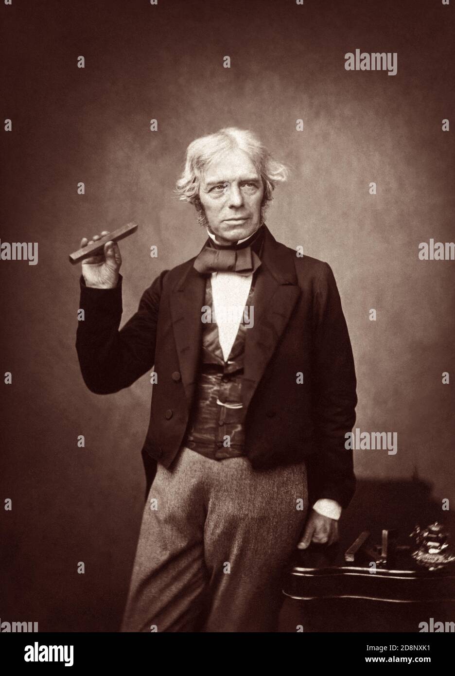 Michael Faraday FRS (1791–1867), einer der einflussreichsten Wissenschaftler der Geschichte, hielt 1857 einen Stabmagneten in einem Porträt von Maull & Polyblank. Stockfoto