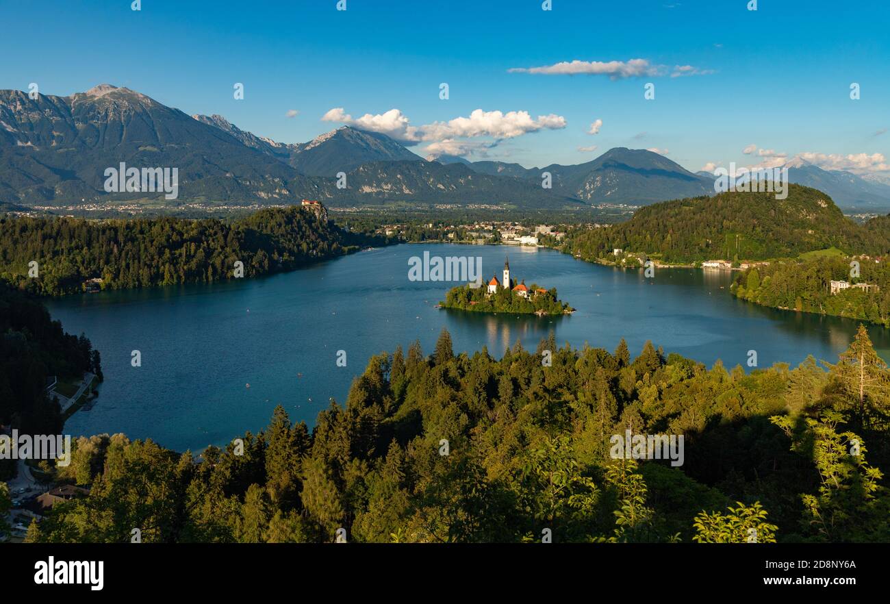 Ein Bild des Bleder Sees und der umliegenden Landschaft, mit der Insel Bled in der Mitte, aus einem Aussichtspunkt gesehen. Stockfoto