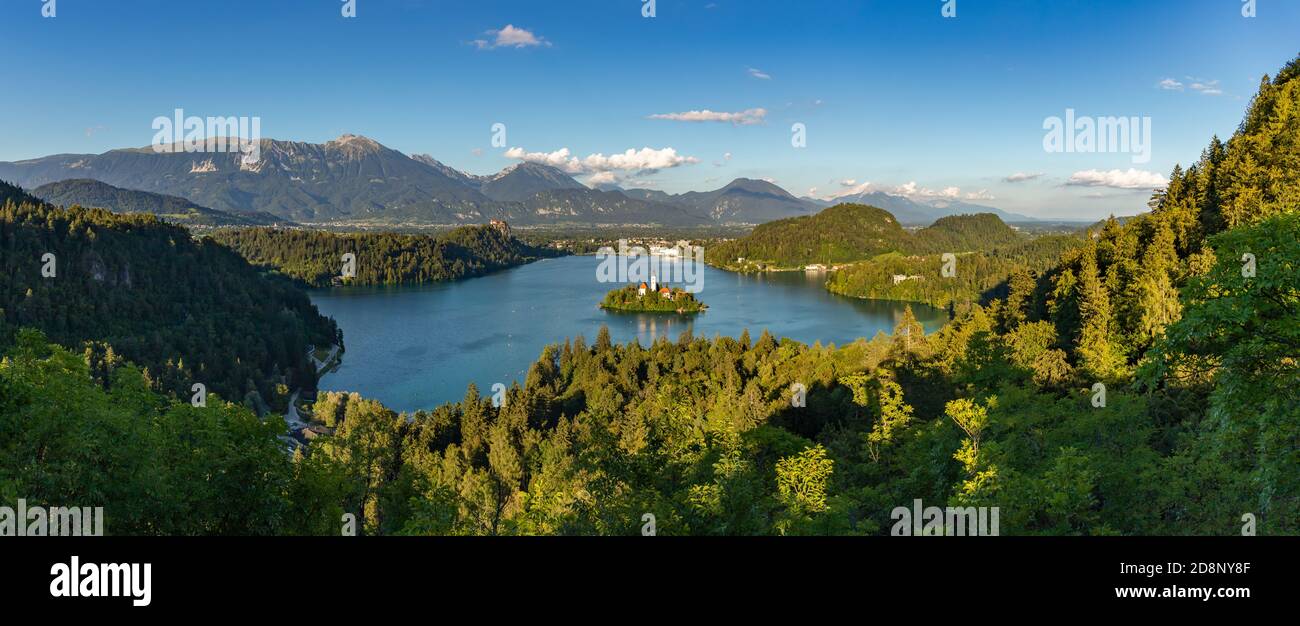 Ein Panoramabild des Bleder Sees und der umliegenden Landschaft, mit der Insel Bled in der Mitte, von einem Aussichtspunkt aus gesehen. Stockfoto