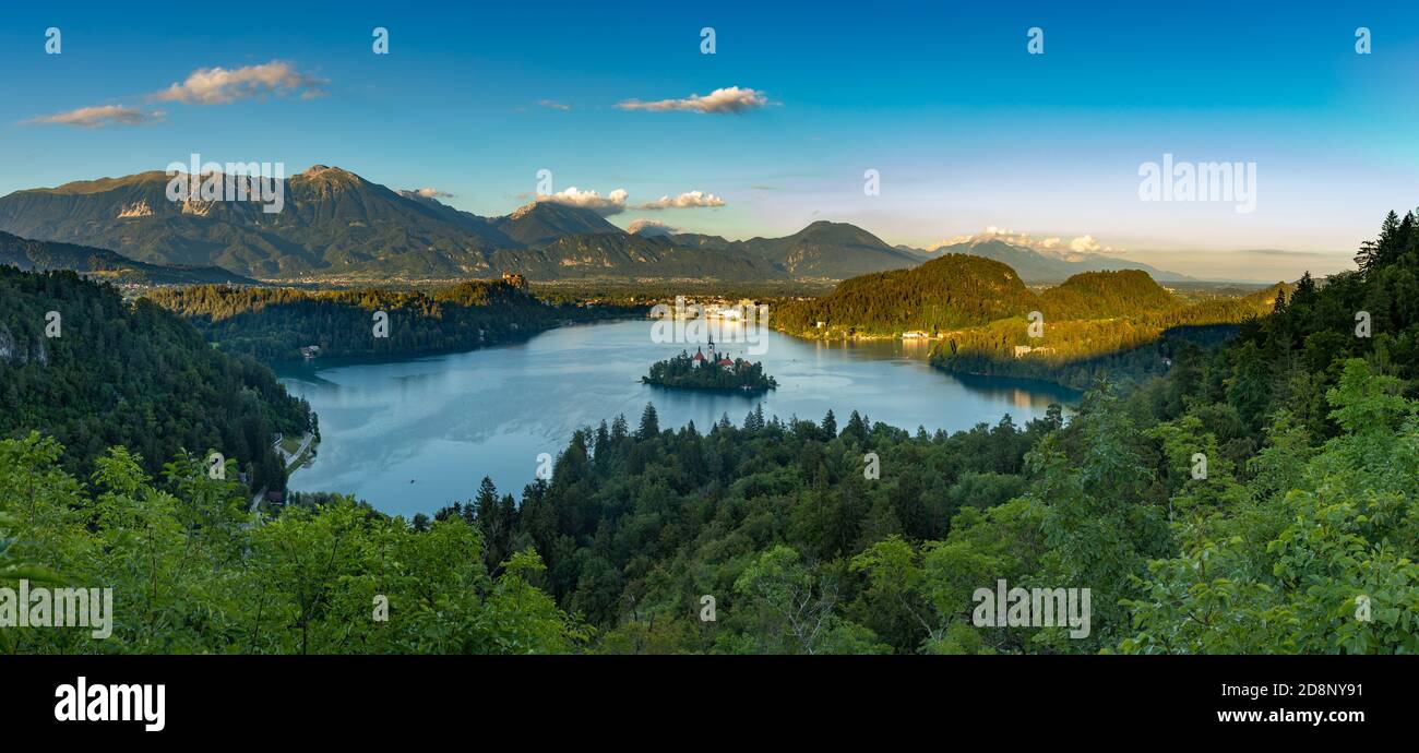 Ein Panoramabild des Bleder Sees und der umliegenden Landschaft, mit der Insel Bled in der Mitte, von einem Aussichtspunkt aus gesehen. Stockfoto