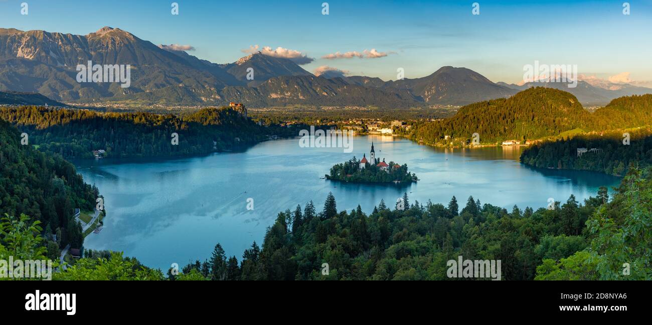 Ein Panoramabild des Bleder Sees und der umliegenden Landschaft, mit der Insel Bled in der Mitte, von einem Aussichtspunkt aus gesehen. Stockfoto