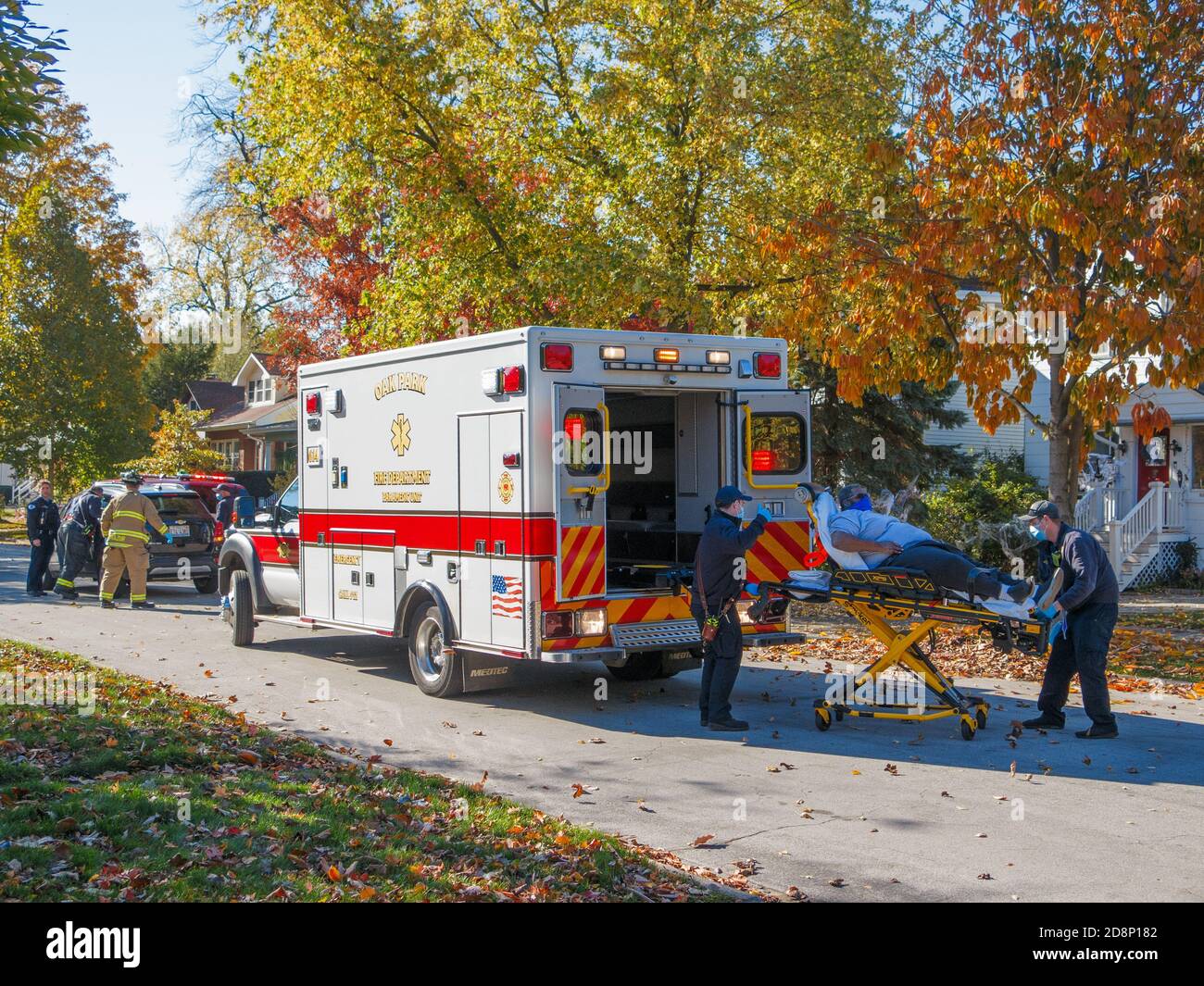 Oak Park, Illinois, USA. Oktober 2020. Sanitäter laden während der COVID-19 Pandemie ein Autounfall-Opfer in einen Krankenwagen. Stockfoto