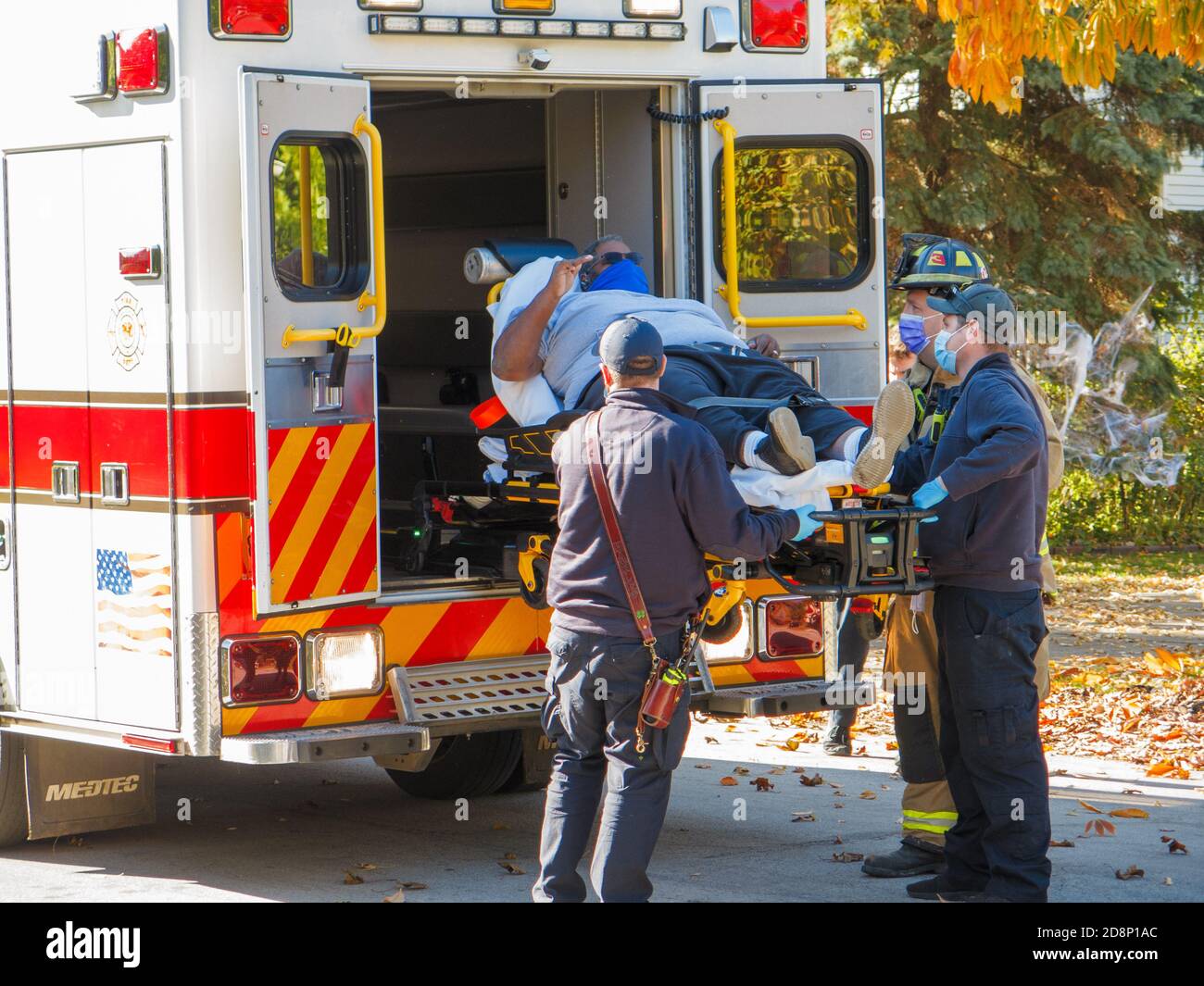Oak Park, Illinois, USA. Oktober 2020. Sanitäter laden während der COVID-19 Pandemie ein Autounfall-Opfer in einen Krankenwagen. Stockfoto