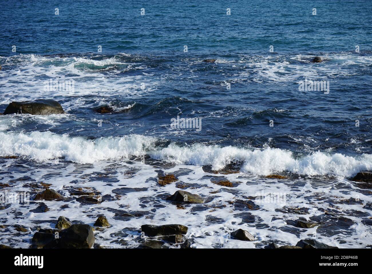 Wunderschöne blaue Wellen mit weißem Schaum am Strand Stockfoto