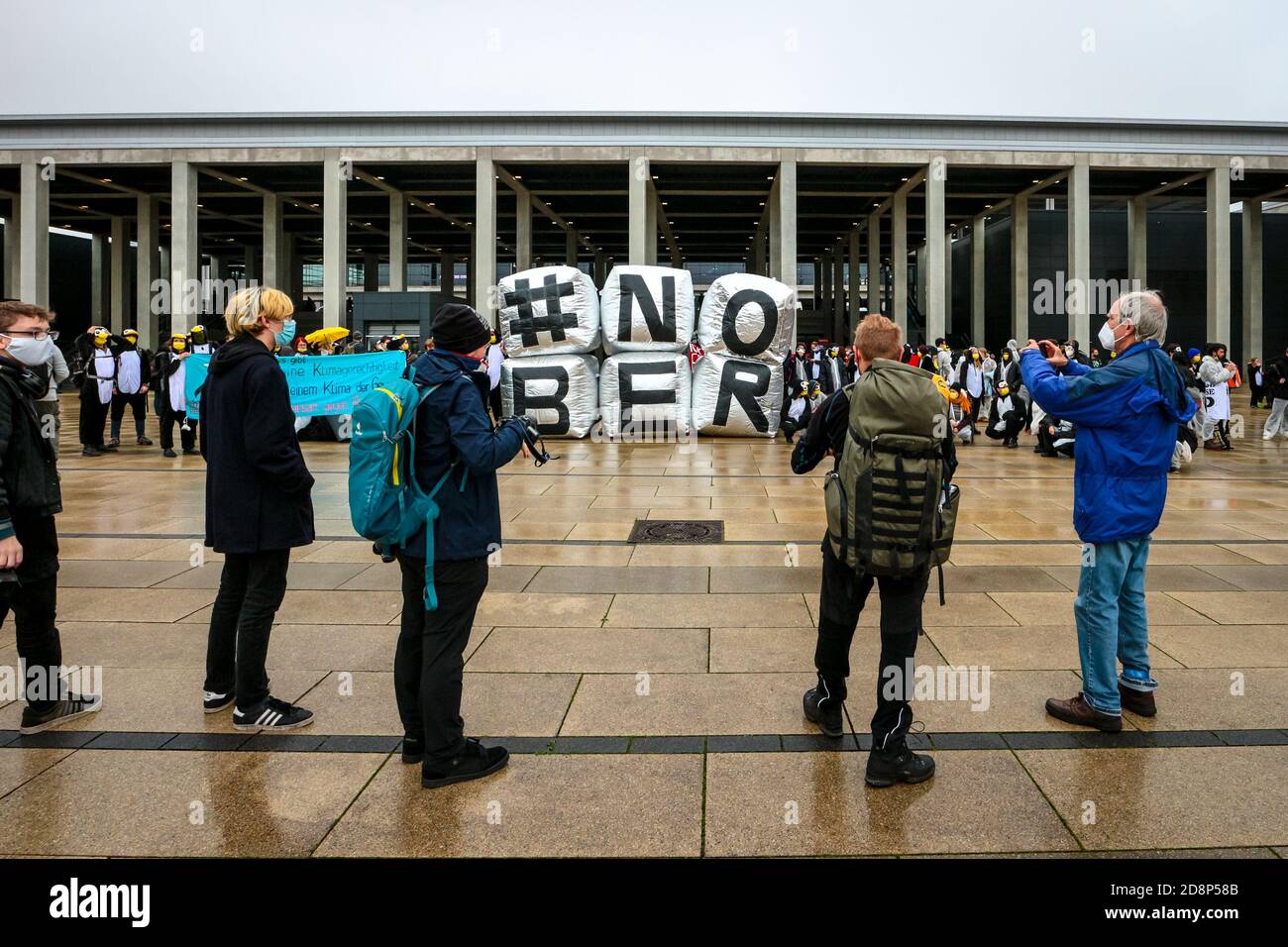 Fotografen fotografieren das Protestschild '#NOBER', während Klimaaktivist gegen die Eröffnung des neuen Flughafens Berlin Brandenburg International (BER) protestieren. Stockfoto