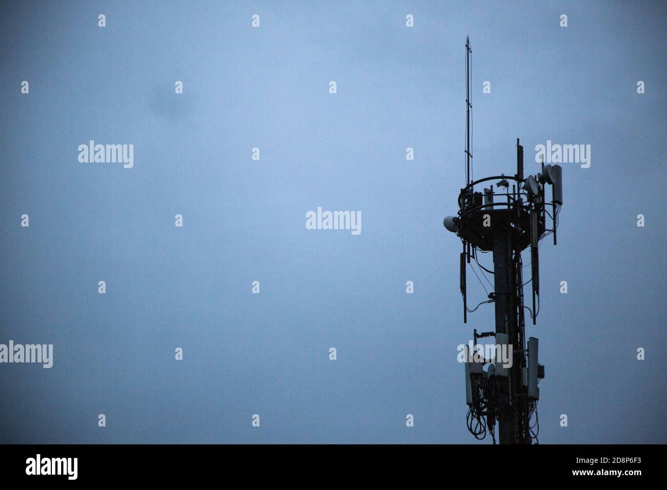 Nahaufnahme von Oberleitungen mit Isolatoren in Telekommunikationsturm Stockfoto