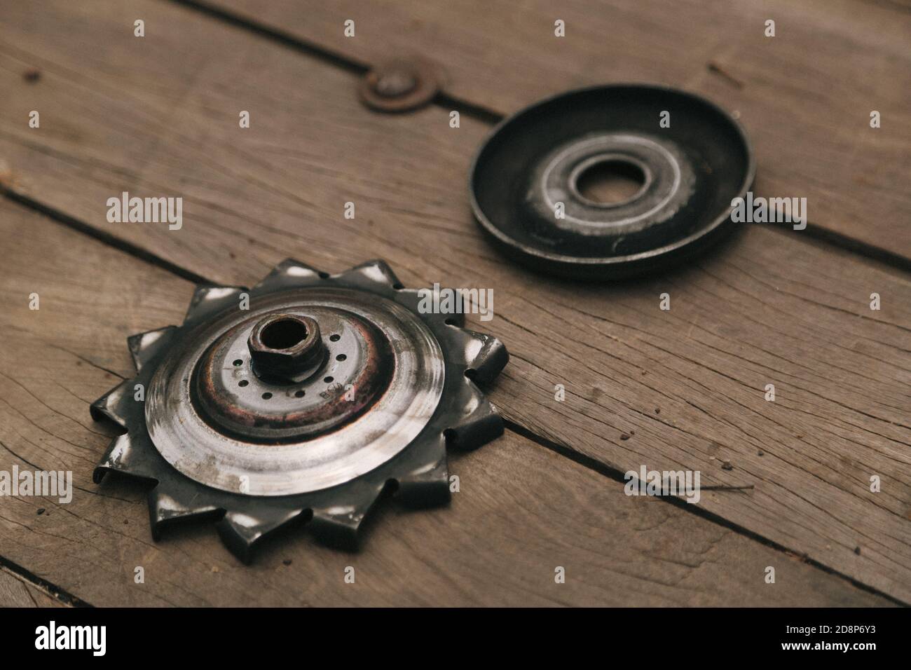 Nahaufnahme von fettigem Fahrradritzel auf einem Holzboden Stockfoto