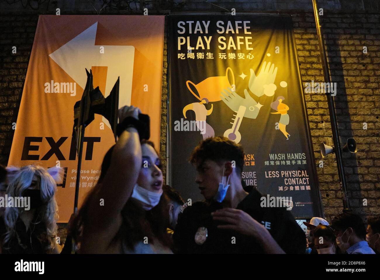 Werbebanner an Halloween.Nachtschwärmer nehmen an einer Halloween-Straßenparty in Lan Kwai Fong inmitten der Covid-19 Pandemie Teil. Stockfoto