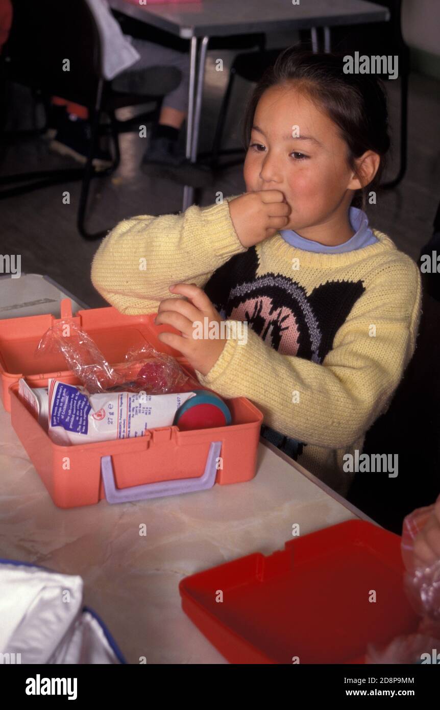 anglo-asiatische Mädchen mit Lunchpaket in der Grundschule Esszimmer Stockfoto