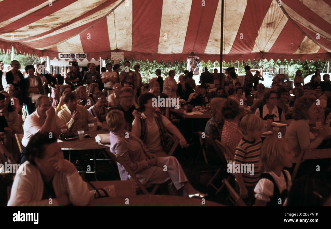 "Die Besucher, die das fünfte jährliche Oktoberfest in Helen besuchten, hörten bayerische Volksmusik und sahen zu, wie die Menschen zu ihr tanzten, sie sahen auch eine Demonstration des amerikanischen Bergs ''Clogging'' (Tanz), die von einer Gruppe von einheimischen Jugendlichen, bekannt als ''Unicoi Cloggers''', aufgeführt wurde. Bier und Würstchen waren für alle Besucher vorhanden. Das Dorf begann das jährliche Festival nach der erfolgreichen Renovierung seines Geschäftsviertels mit einem alpinen Thema' Stockfoto