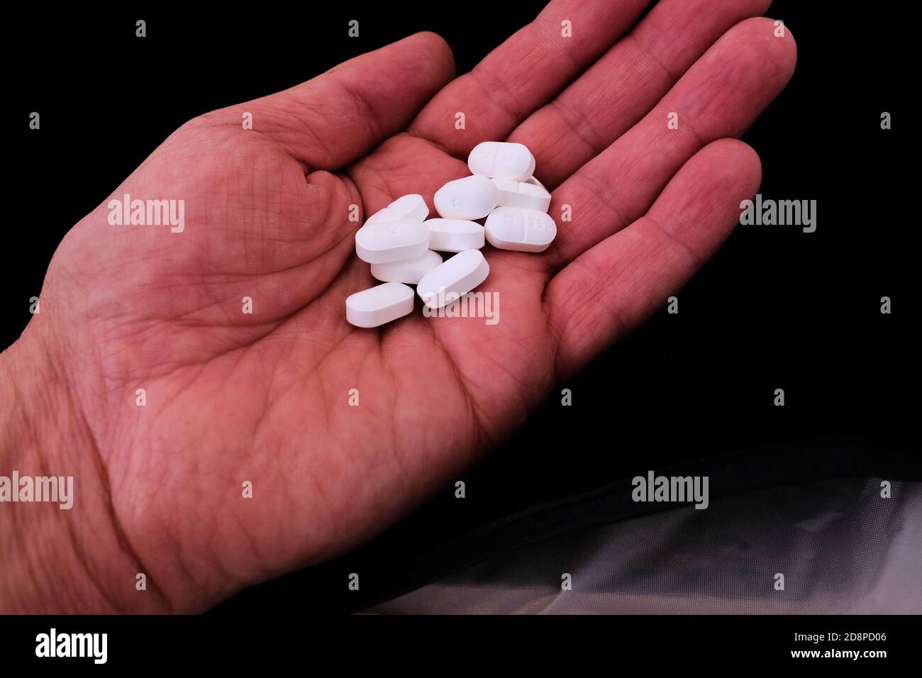 Hydrocodon mit Acetaminophen Pillen in der Hand eines Mannes; für Post-Operation Schmerzen und Erholung verschrieben; Opioid Krise und sucht. Stockfoto