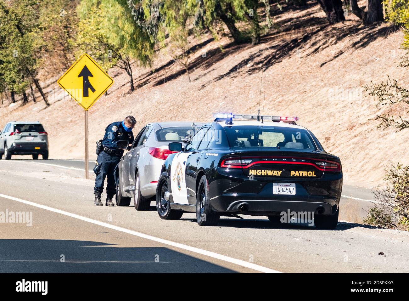 Oct 14, 2020 Fremont / CA / USA - Highway Patrol Officer schreibt ein Verkehrsticket an einen Fahrer, der auf der rechten Straßenseite herüberfährt Stockfoto