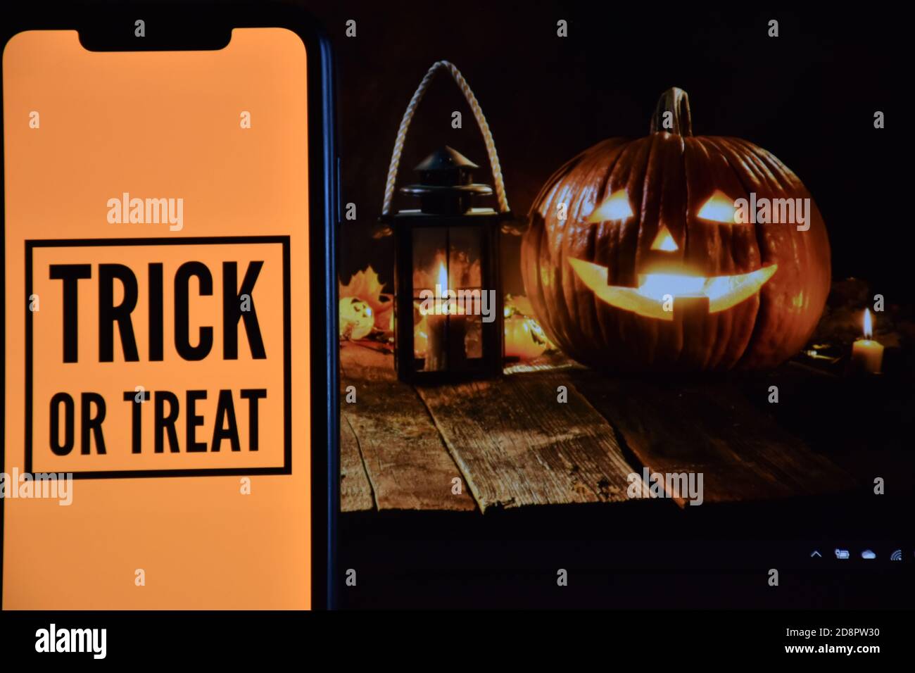 Trick or Treat Text auf Handy mit Halloween-Hintergrund Stockfoto