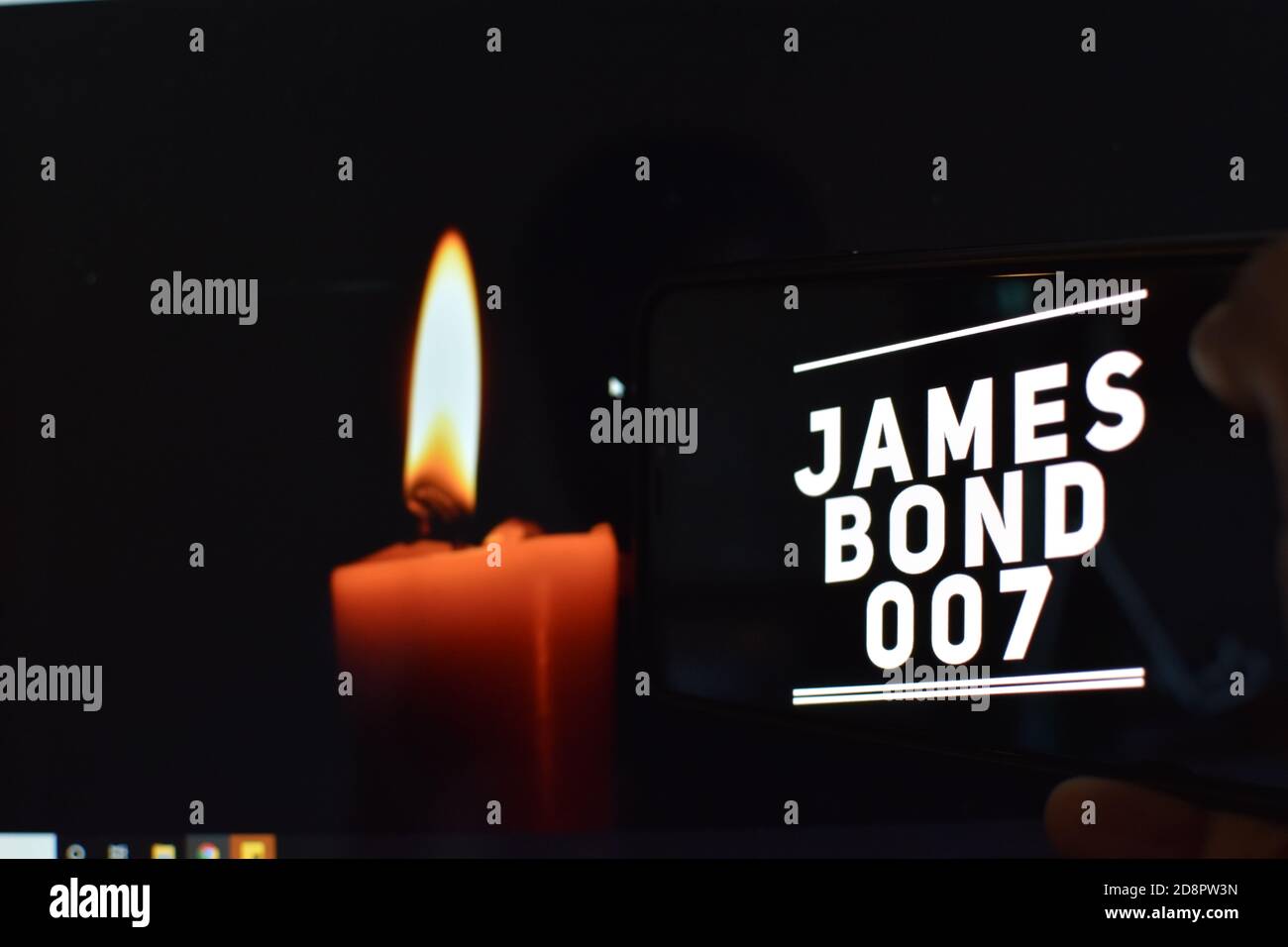007 Text auf Handy mit Kerzenhintergrund, james Bond Stockfoto