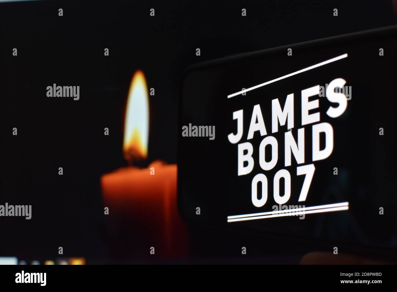 007 Text auf Handy mit Kerzenhintergrund, james Bond Stockfoto