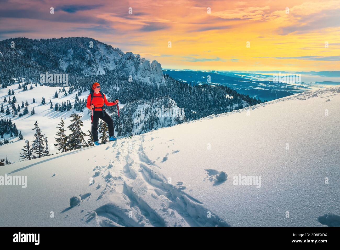 Fröhliche sportliche Frau auf frischem Pulverschnee, Skitouren auf den verschneiten Hügeln. Backcountry Skifahrerin Frau mit Rucksack genießen die Aussicht bei Sonnenuntergang, Carpath Stockfoto