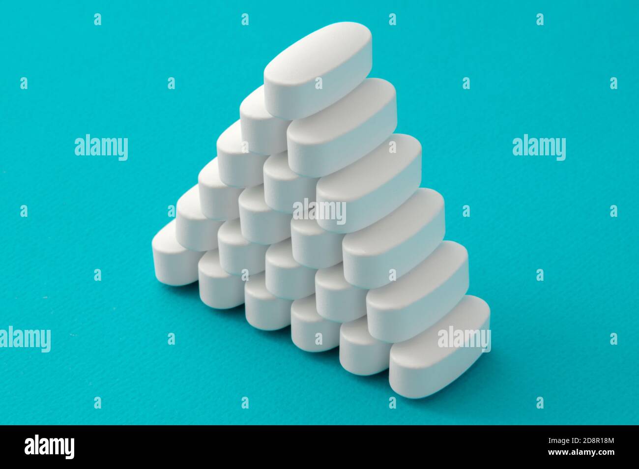 Pirayd aus weißen Medikamenten Pillen auf cyanfarbenem Hintergrund Stockfoto
