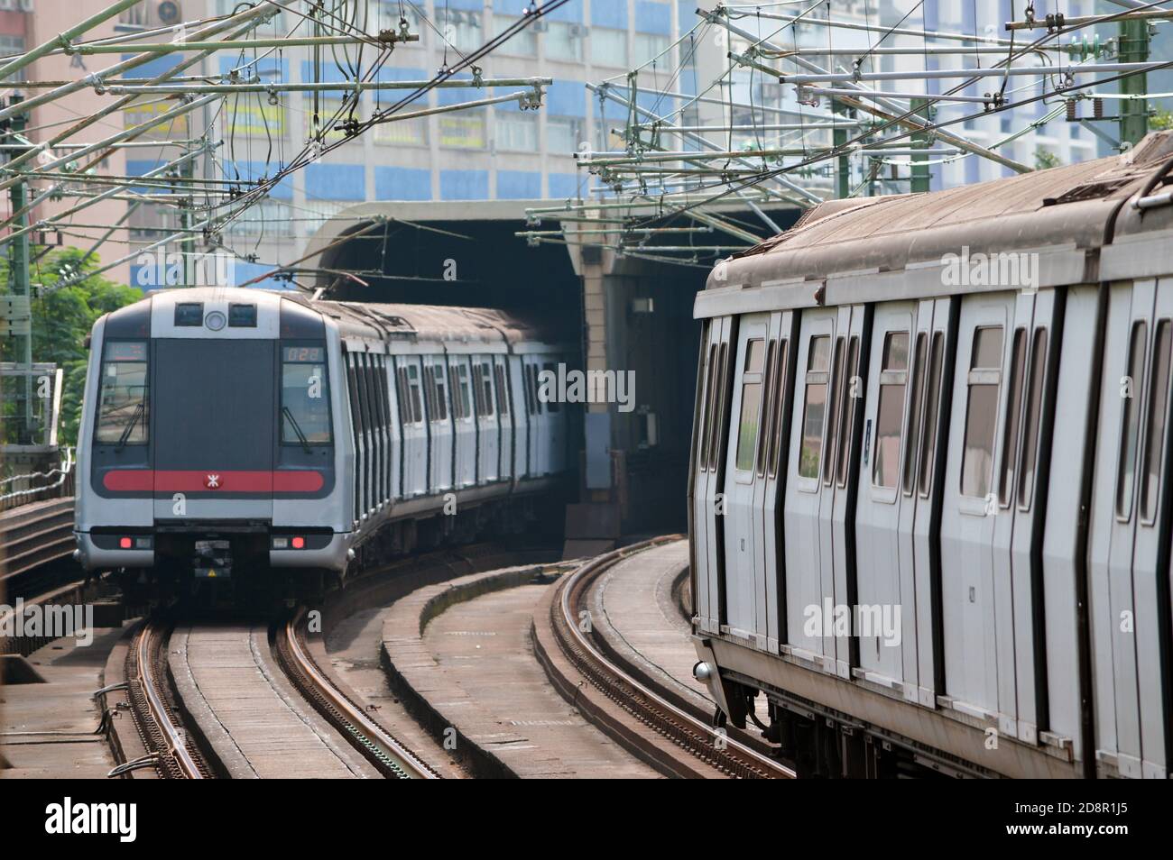 Züge fahren in der Nähe eines akustischen Gehäuses auf der Tsuen Wan Line des MTR-Systems von Hongkong, 2020 Stockfoto