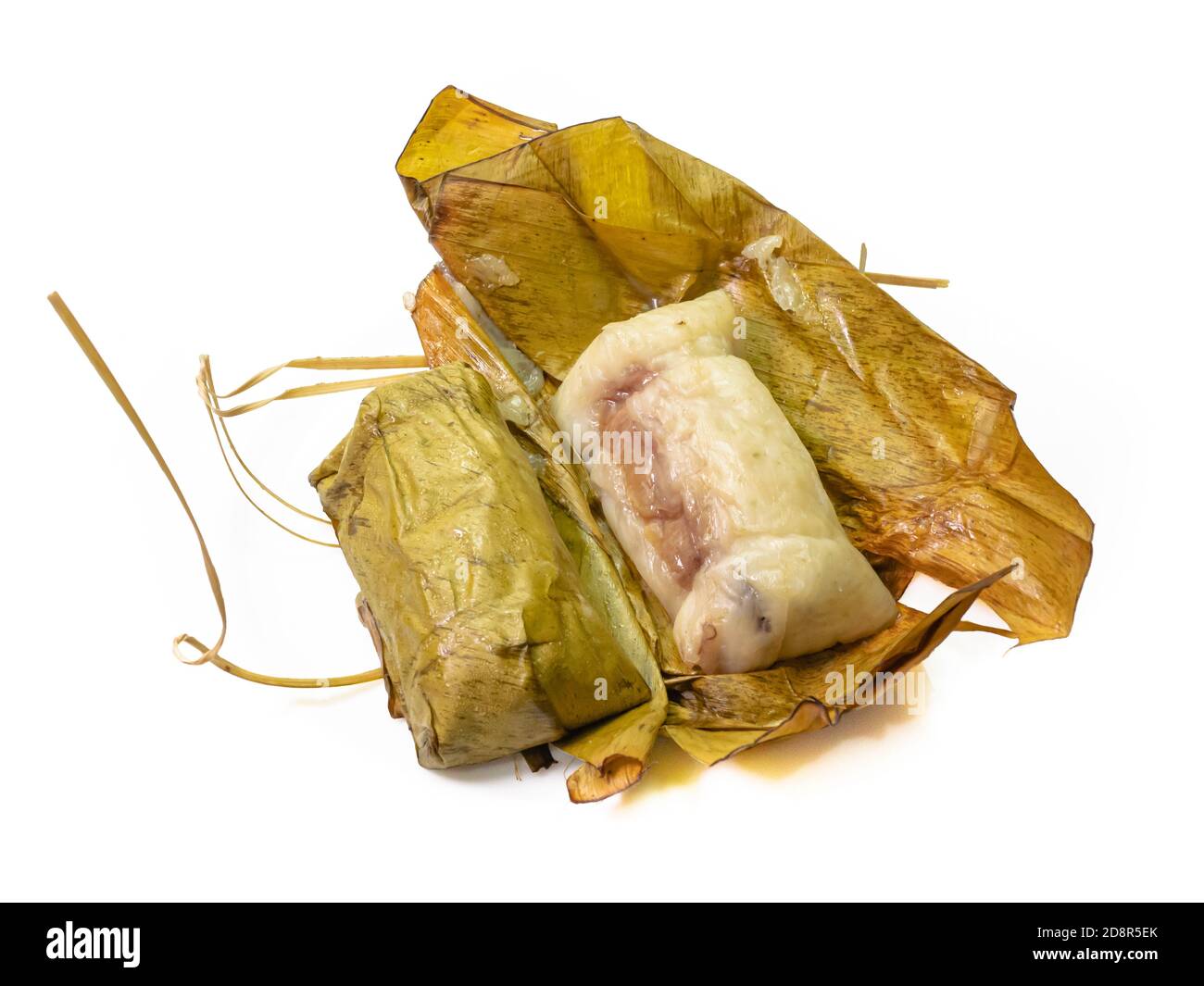 Die Nahaufnahme von Thai gedämpftem klebrigem Reis mit Kokosmilch und Banane (Khao Tom Mud) umhüllt von Bananenblatt auf weißem Hintergrund. Stockfoto