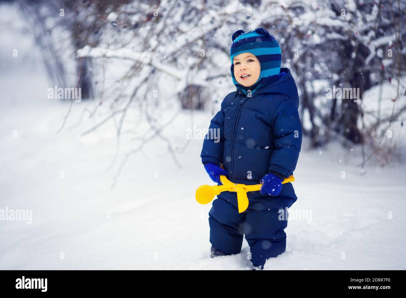 Kleiner Junge mit Spielzeug für die Herstellung von Schneebällen Stockfoto