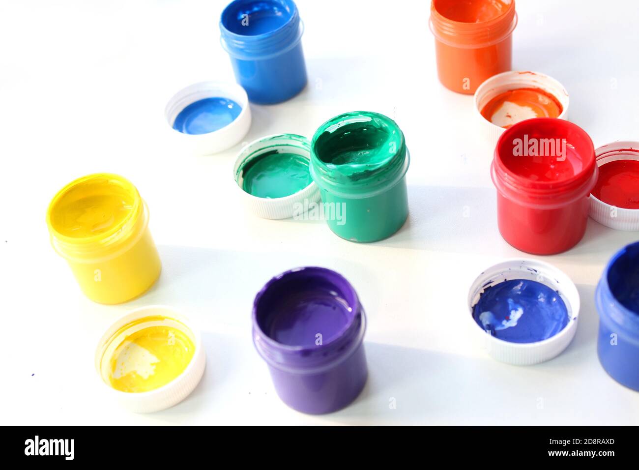 Offene Gouache-Gläser auf weißem Hintergrund, flache Lay-Komposition, Draufsicht.Copy space.Flat Lay-Komposition mit Gouache-Farben und Pinsel.Werbung Stockfoto
