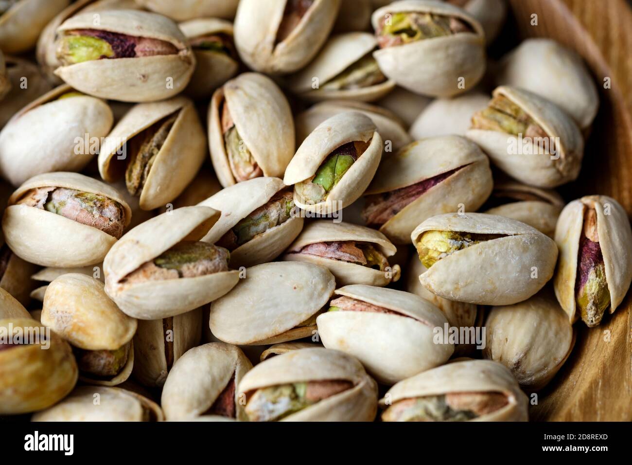 Nahaufnahme einer Schüssel gesunder gerösteter Pistazien in teilweise offenen Schalen. Die Nüsse enthalten Vitamin B6 und Vitamin E. Stockfoto