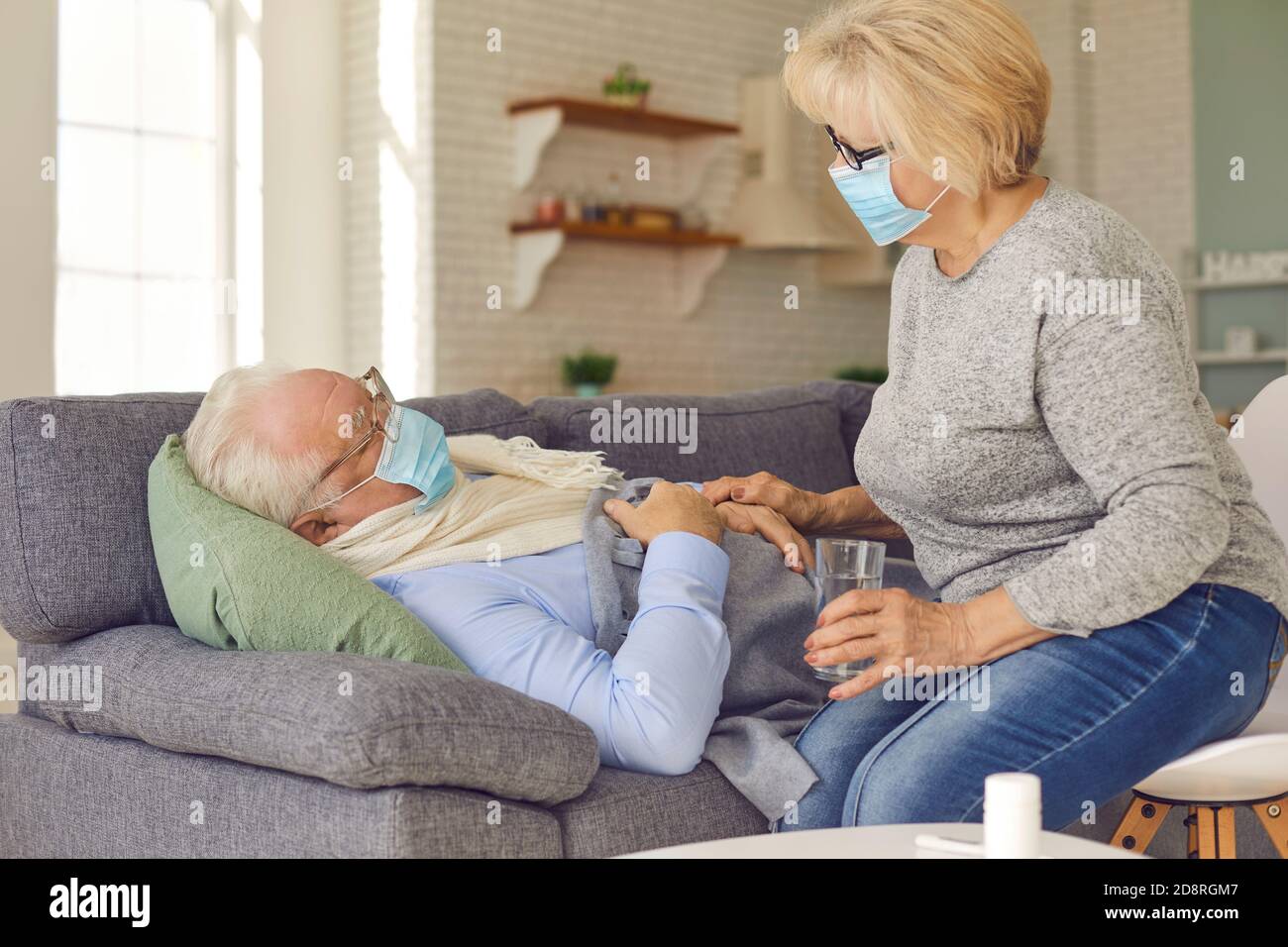 Ältere Frau hilft kranken Mann Medizin zu nehmen und zu fragen Wenn er etwas braucht Stockfoto