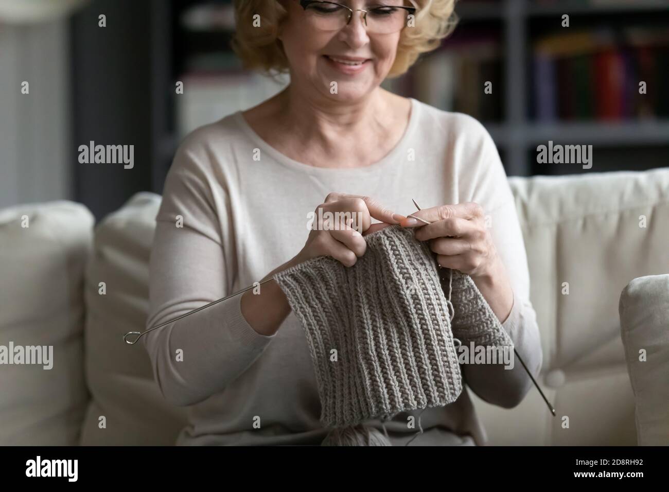 Glückliche ältere ältere 60s Frau Stricken warme Kleidung. Stockfoto