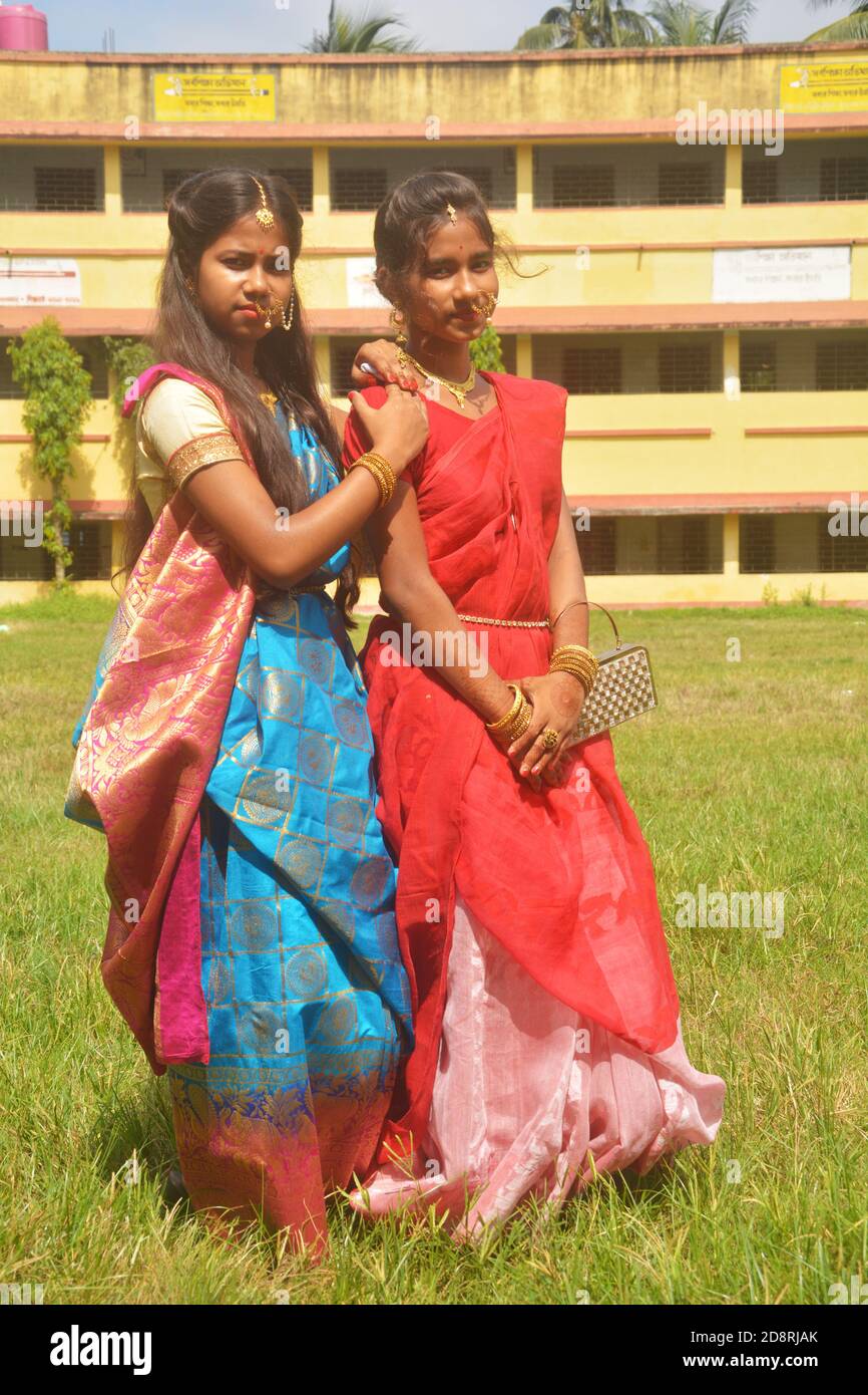 Nahaufnahme von zwei Schwestern tragen traditionelle Saree und Schmuck wie Nasenringe Ohrringe maang tika Armreifen während Durga Puja, selektive Fokussierung Stockfoto
