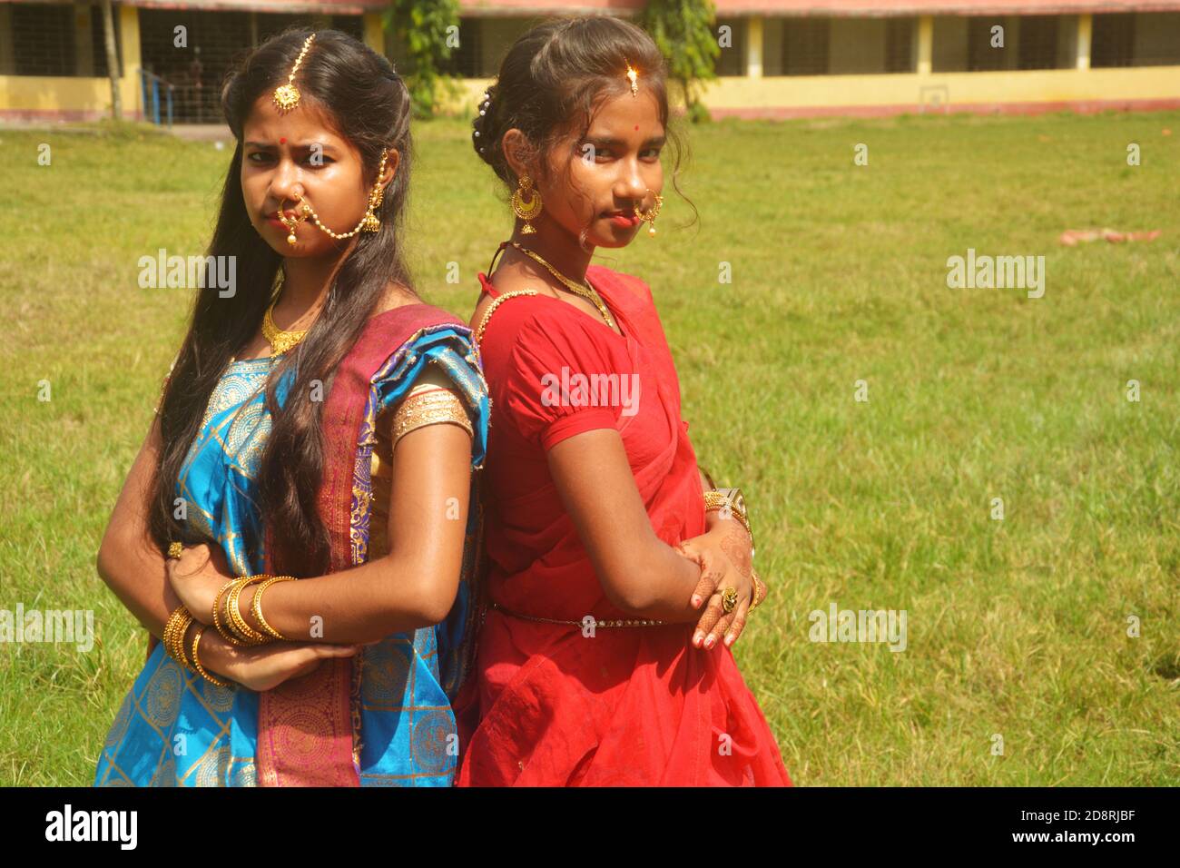 Nahaufnahme von zwei Schwestern tragen traditionelle Saree und Schmuck wie Nasenringe Ohrringe maang tika Armreifen während Durga Puja, selektive Fokussierung Stockfoto