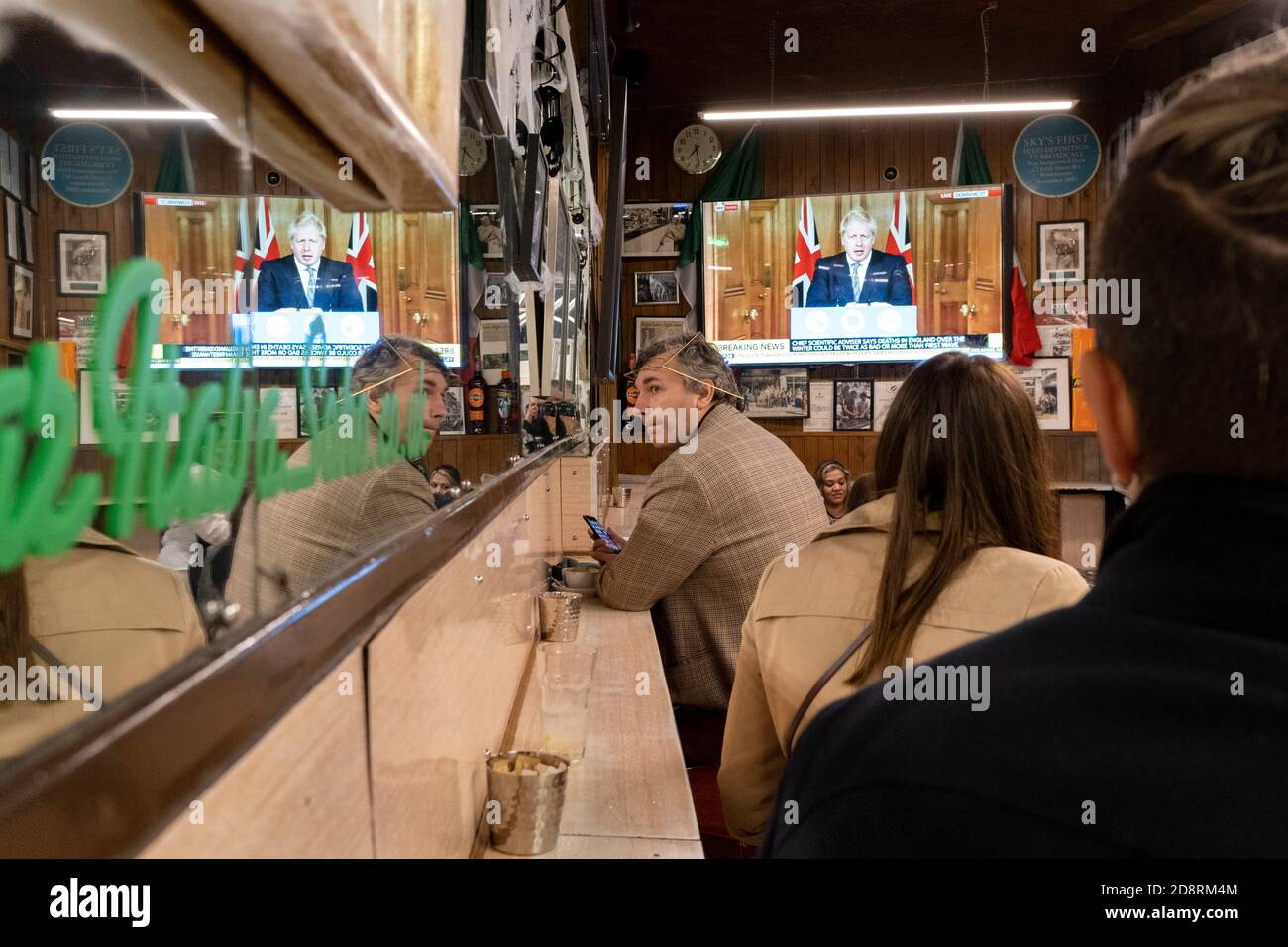 Auf einem Fernsehbildschirm in Bar Italia, dem berühmten italienischen Café in Soho, spricht Premierminister Boris Johnson Großbritannien im Live-Fernsehen an, um eine zweite landesweite Sperre während der zweiten Welle der Coronavirus-Pandemie am 31. Oktober 2020 in London, England, anzukündigen. Unternehmen wie die Bar Italia müssen bis auf Takeaways wieder geschlossen werden, und zwar ab Mitternacht am Donnerstag für einen Zeitraum von einem Monat. Stockfoto