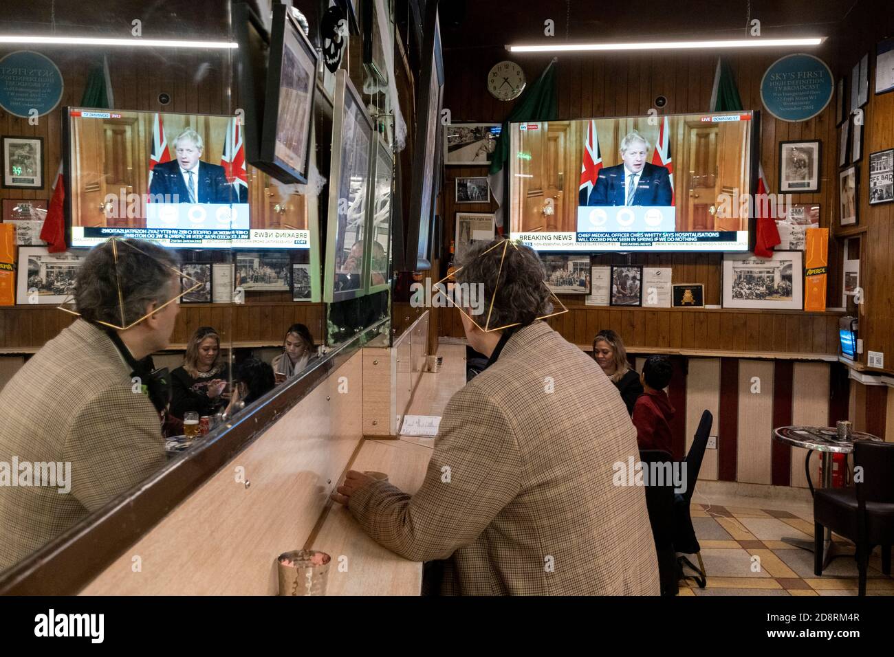 Auf einem Fernsehbildschirm in Bar Italia, dem berühmten italienischen Café in Soho, spricht Premierminister Boris Johnson Großbritannien im Live-Fernsehen an, um eine zweite landesweite Sperre während der zweiten Welle der Coronavirus-Pandemie am 31. Oktober 2020 in London, England, anzukündigen. Unternehmen wie die Bar Italia müssen bis auf Takeaways wieder geschlossen werden, und zwar ab Mitternacht am Donnerstag für einen Zeitraum von einem Monat. Stockfoto