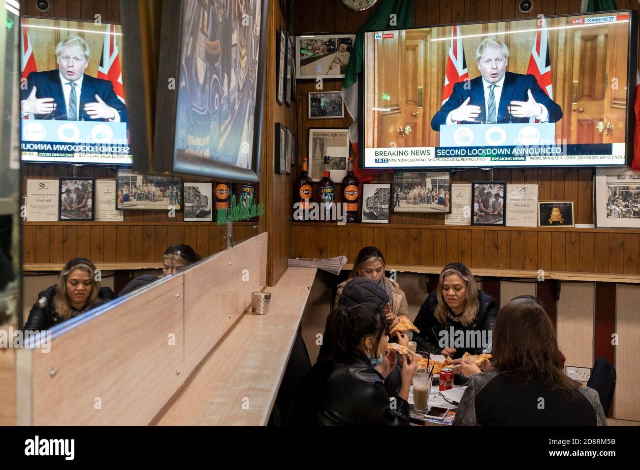 Auf einem Fernsehbildschirm in Bar Italia, dem berühmten italienischen Café in Soho, spricht Premierminister Boris Johnson Großbritannien im Live-Fernsehen an, um eine zweite landesweite Sperre während der zweiten Welle der Coronavirus-Pandemie am 31. Oktober 2020 in London, England, anzukündigen. Unternehmen wie die Bar Italia müssen bis auf Takeaways wieder geschlossen werden, und zwar ab Mitternacht am Donnerstag für einen Zeitraum von einem Monat. Stockfoto