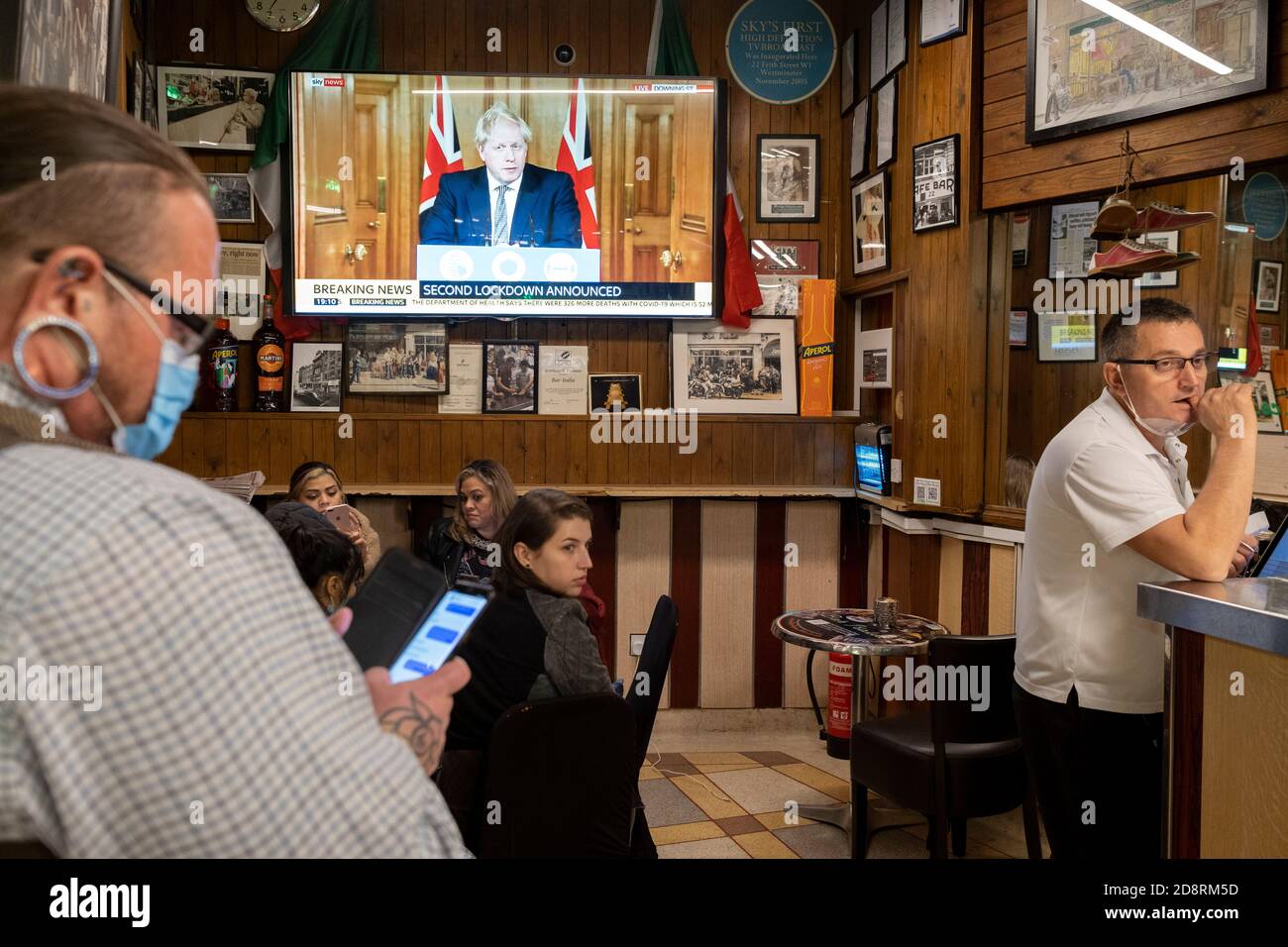 Auf einem Fernsehbildschirm in Bar Italia, dem berühmten italienischen Café in Soho, spricht Premierminister Boris Johnson Großbritannien im Live-Fernsehen an, um eine zweite landesweite Sperre während der zweiten Welle der Coronavirus-Pandemie am 31. Oktober 2020 in London, England, anzukündigen. Unternehmen wie die Bar Italia müssen bis auf Takeaways wieder geschlossen werden, und zwar ab Mitternacht am Donnerstag für einen Zeitraum von einem Monat. Stockfoto