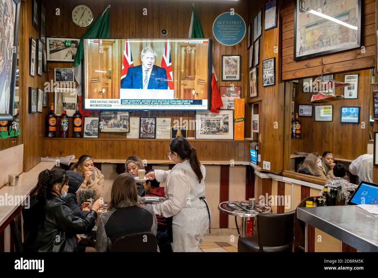 Auf einem Fernsehbildschirm in Bar Italia, dem berühmten italienischen Café in Soho, spricht Premierminister Boris Johnson Großbritannien im Live-Fernsehen an, um eine zweite landesweite Sperre während der zweiten Welle der Coronavirus-Pandemie am 31. Oktober 2020 in London, England, anzukündigen. Unternehmen wie die Bar Italia müssen bis auf Takeaways wieder geschlossen werden, und zwar ab Mitternacht am Donnerstag für einen Zeitraum von einem Monat. Stockfoto