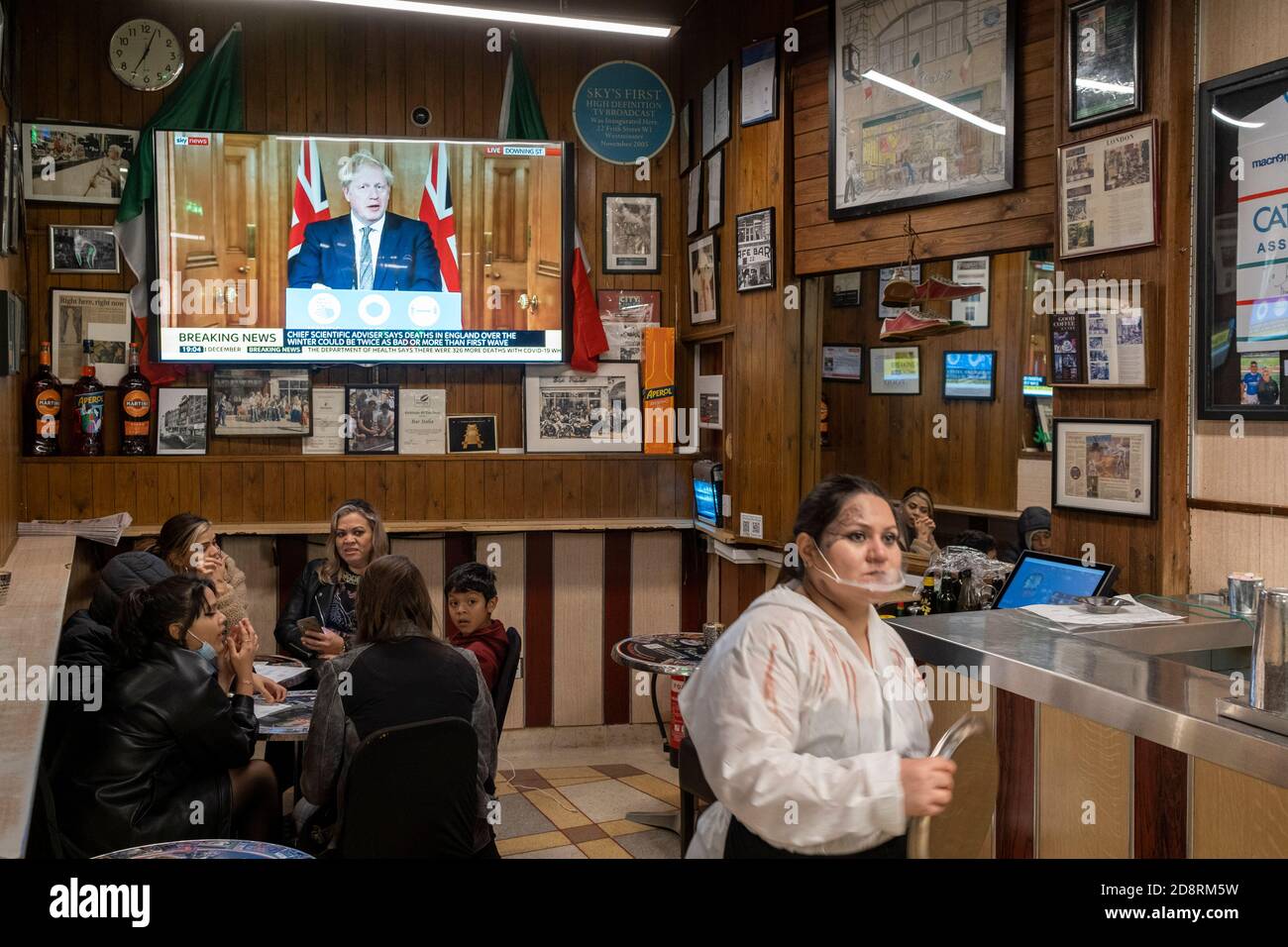 Auf einem Fernsehbildschirm in Bar Italia, dem berühmten italienischen Café in Soho, spricht Premierminister Boris Johnson Großbritannien im Live-Fernsehen an, um eine zweite landesweite Sperre während der zweiten Welle der Coronavirus-Pandemie am 31. Oktober 2020 in London, England, anzukündigen. Unternehmen wie die Bar Italia müssen bis auf Takeaways wieder geschlossen werden, und zwar ab Mitternacht am Donnerstag für einen Zeitraum von einem Monat. Stockfoto