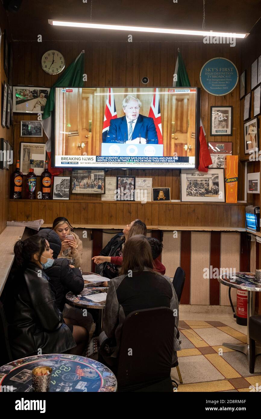 Auf einem Fernsehbildschirm in Bar Italia, dem berühmten italienischen Café in Soho, spricht Premierminister Boris Johnson Großbritannien im Live-Fernsehen an, um eine zweite landesweite Sperre während der zweiten Welle der Coronavirus-Pandemie am 31. Oktober 2020 in London, England, anzukündigen. Unternehmen wie die Bar Italia müssen bis auf Takeaways wieder geschlossen werden, und zwar ab Mitternacht am Donnerstag für einen Zeitraum von einem Monat. Stockfoto